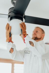 Penguin Air Technician Installing Ceiling Fan