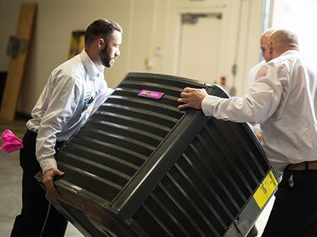 Two HVAC technicians installing a new system
