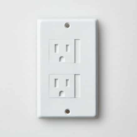 White electrical outlet against white wall in residential home.