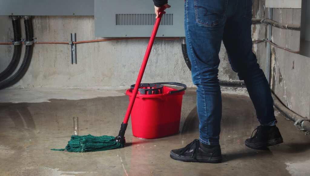 Homeowner mopping flooded basement