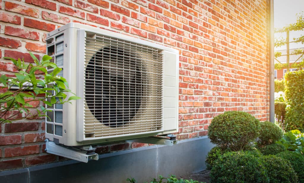 Heat pump mounted on the side of a brick home