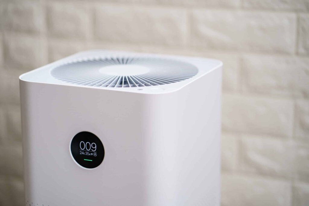 Close up image of an air purifier with an indoor air quality monitor.