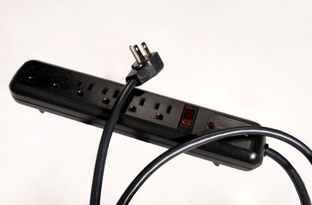 Close-up of a black electrical surge protector on white background.