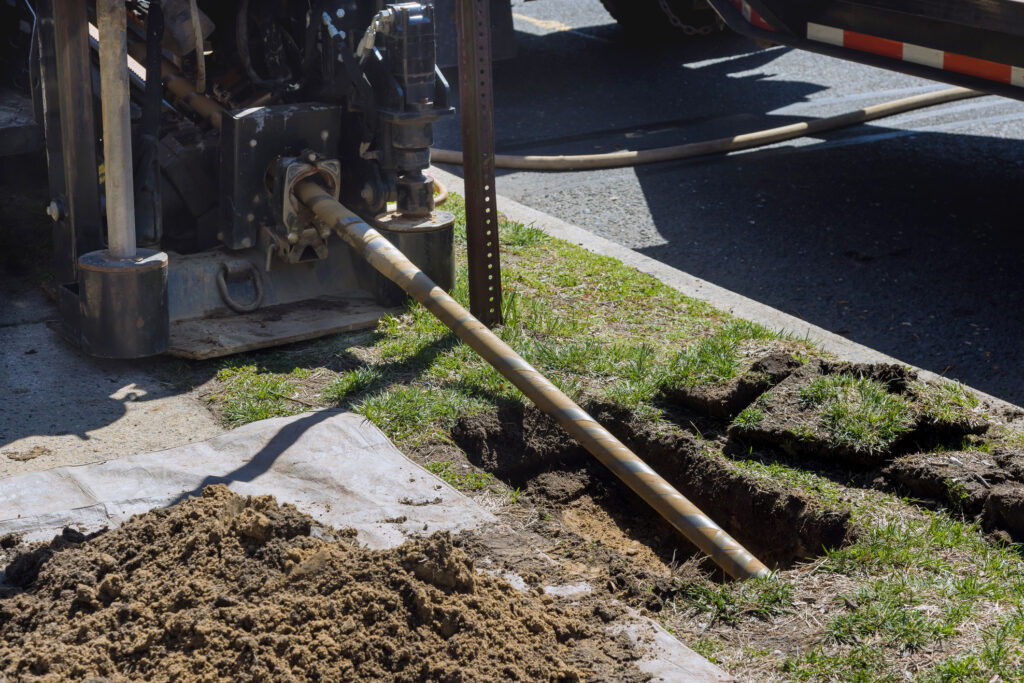 Low angle view of trenchless laying of communications, fiber optic, and water pipes with horizontal directional drilling technology machine work process.